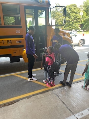 Senior Bobcats helping Baby Bobcats on to Buses